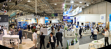 „Gut besuchte Messehalle mit zahlreichen Ausstellungsständen der maritimen Industrie.“